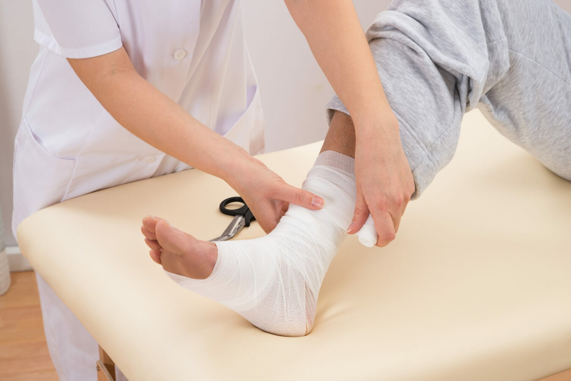 Woman Tying Bandage On Patient's Foot